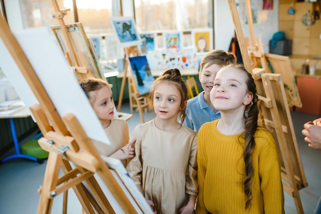 Kinder in der Grundschule machen einen Museumsrundgang und reflektieren dabei über ihre Bilder aus dem Kunstunterricht.