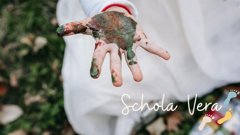 Warum unsere Schule keine Noten, Fächer oder Jahrgänge braucht (Newsletter 5/2025) 1 Ein Kind in unserer eigenen Schule, der Schola Vera, dass vom Ausprobieren mit Farben eine ganz bunte Hand hat.