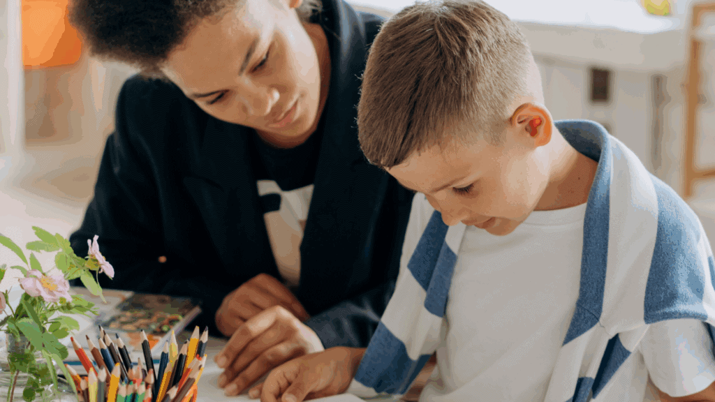 Eine Klassenlehrerin, die ihrem Schüler bei seinen Aufgaben hilft