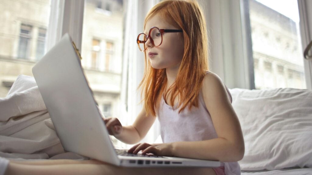 Schreibschrift-Unterricht in der Grundschule revolutionieren: So geht's (Klassen 1-3) 2 Ein junges Mädchen mit Brille, wie sie einen Laptop benutzt.