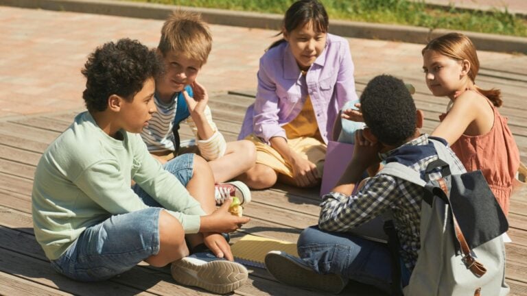 Fünf Kinder sitzen im Kreis und bilden eine starke Klassengemeinschaft