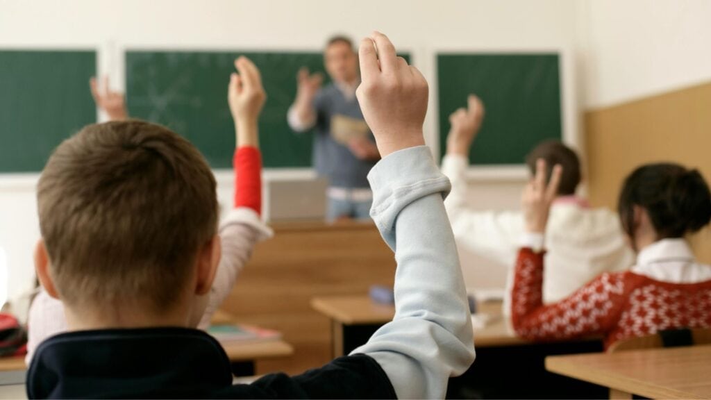 Kinder, die sich im Unterricht melden